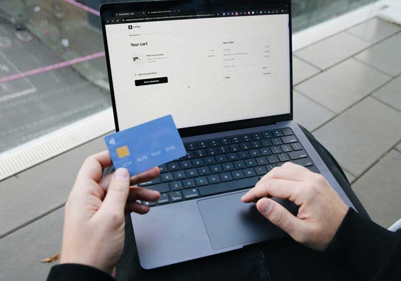 person on laptop with credit card paying