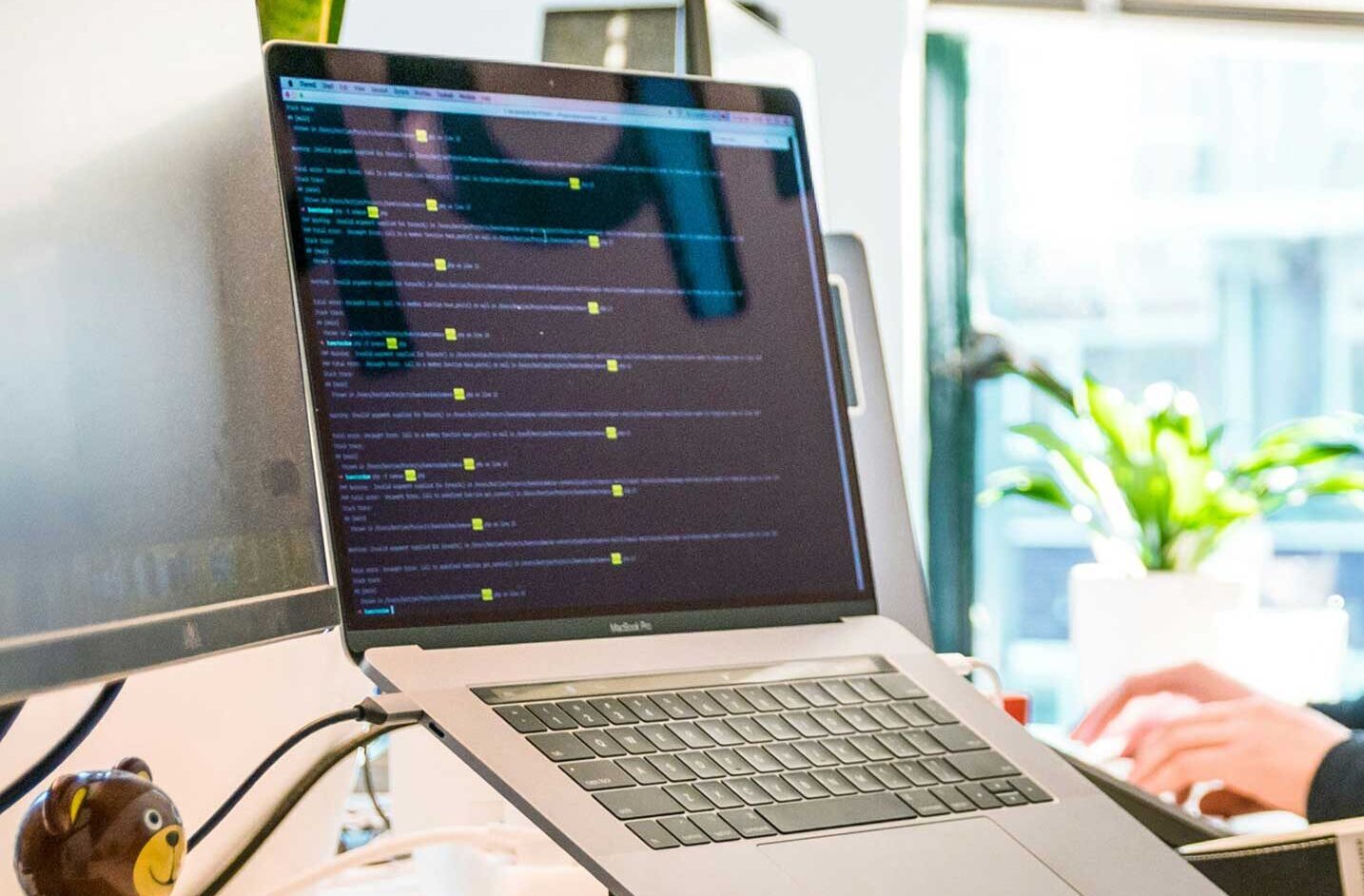 laptop and monitor on desk with hands